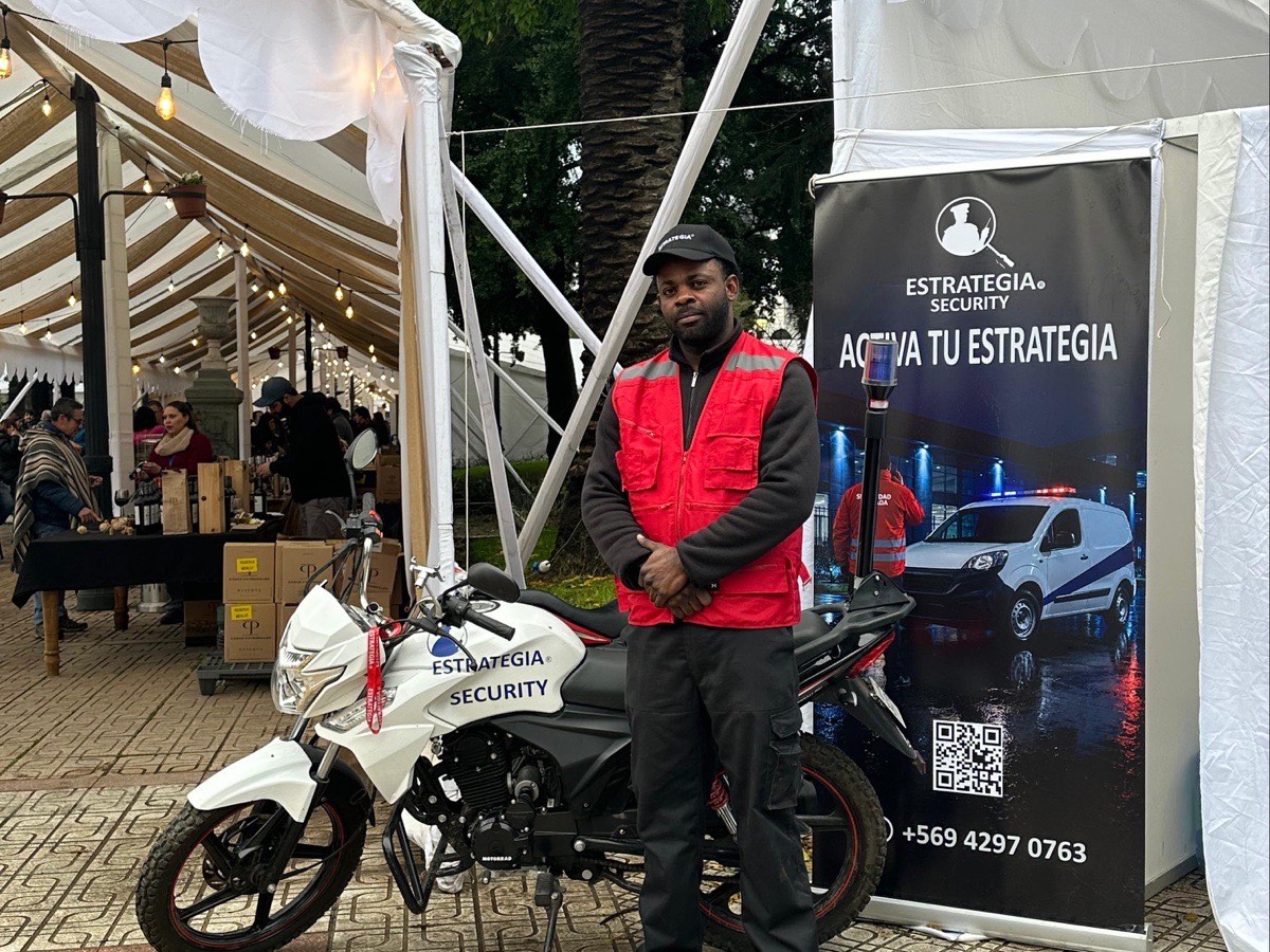 Guardia de Estrategia Security con chaleco reflectante junto a la moto de patrullaje en la Fiesta Costumbrista del Chancho de Talca 2026